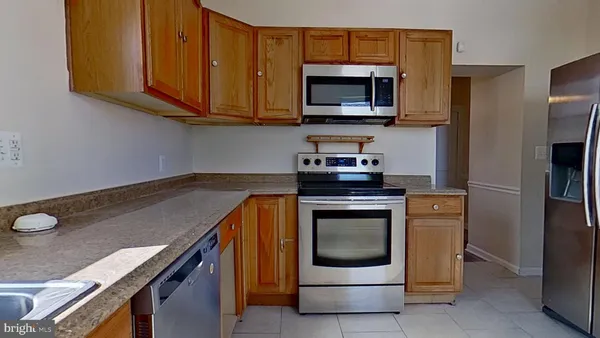 a kitchen with stainless steel appliances granite countertop a stove microwave and refrigerator