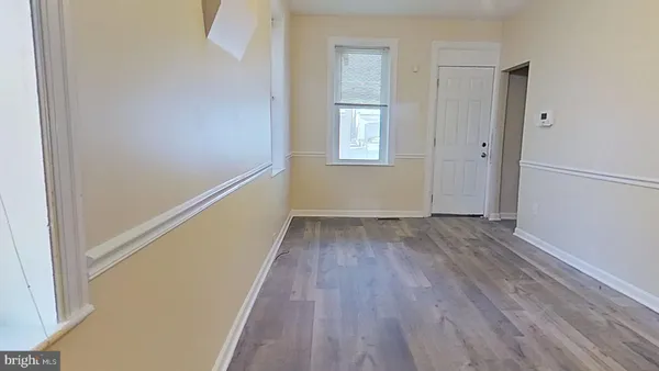 a view of hallway with window and wooden floor