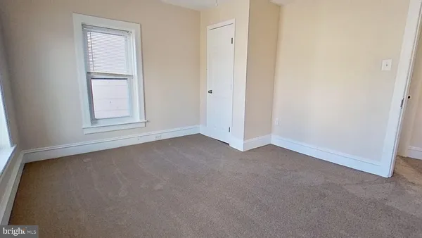 an empty room with windows and closet