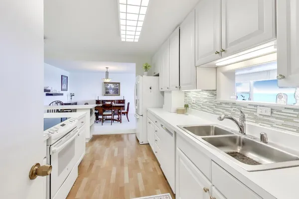 a kitchen with granite countertop a sink counter top space and cabinets
