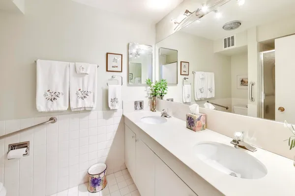 a bathroom with a double vanity sink mirror and toilet