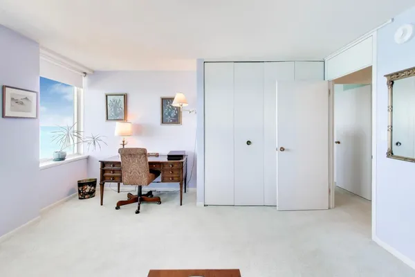 a view of a workspace with furniture and a window