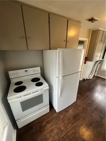 a white refrigerator freezer and a stove sitting inside of a kitchen