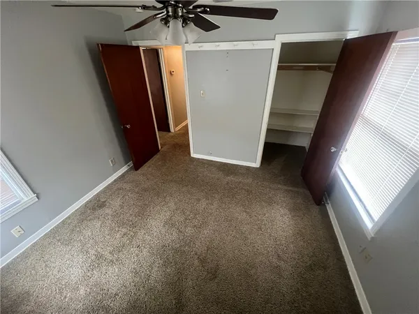 a view of a livingroom with a ceiling fan and window