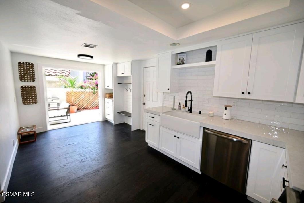 979 Thistlegate Road Oak Park, CA 91377 - Photo 12 of 19 a open kitchen with a sink and dishwasher with white cabinets