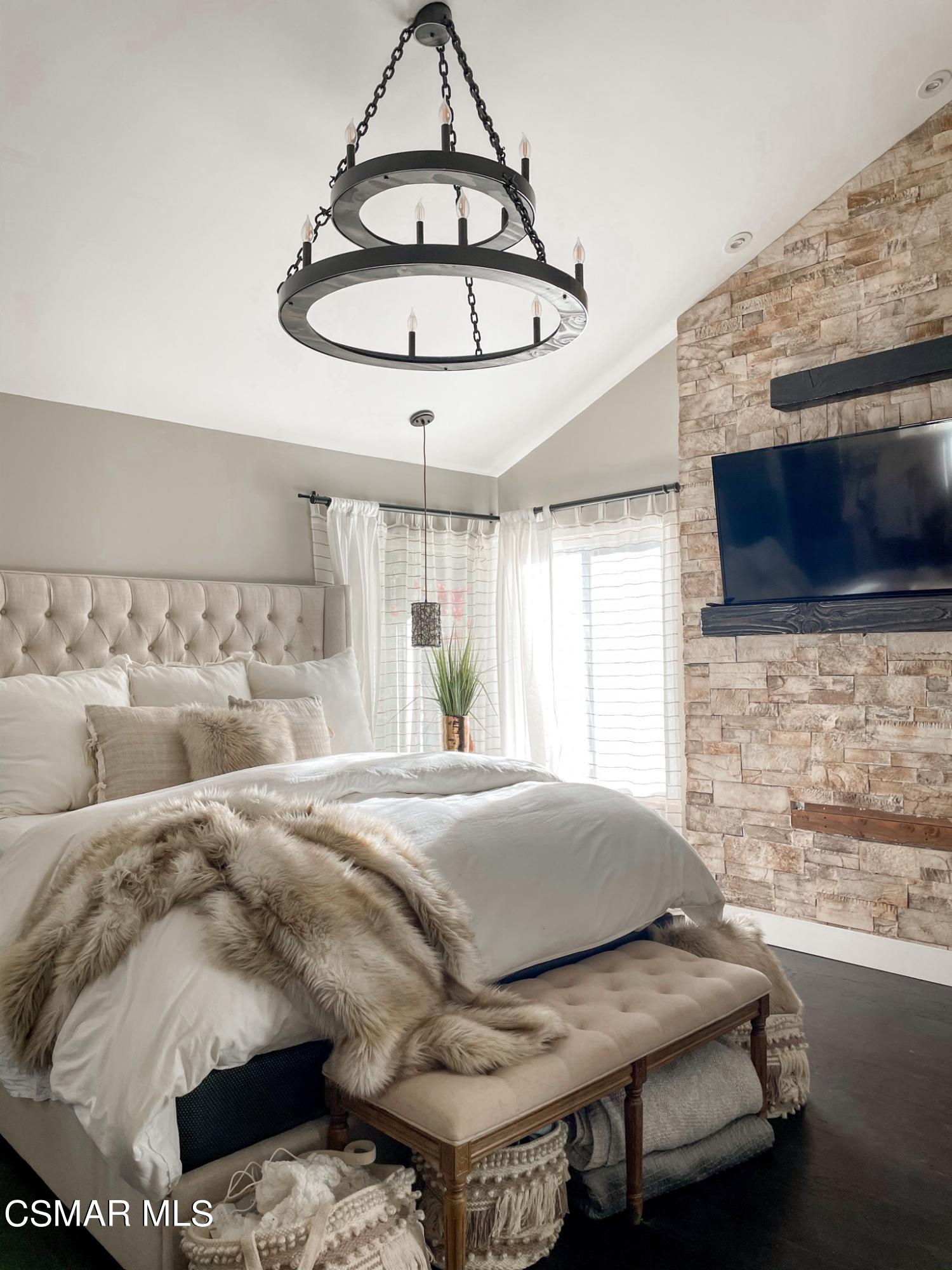 979 Thistlegate Road Oak Park, CA 91377 - Photo 14 of 19 a bedroom with a bed a chandelier and flat screen tv