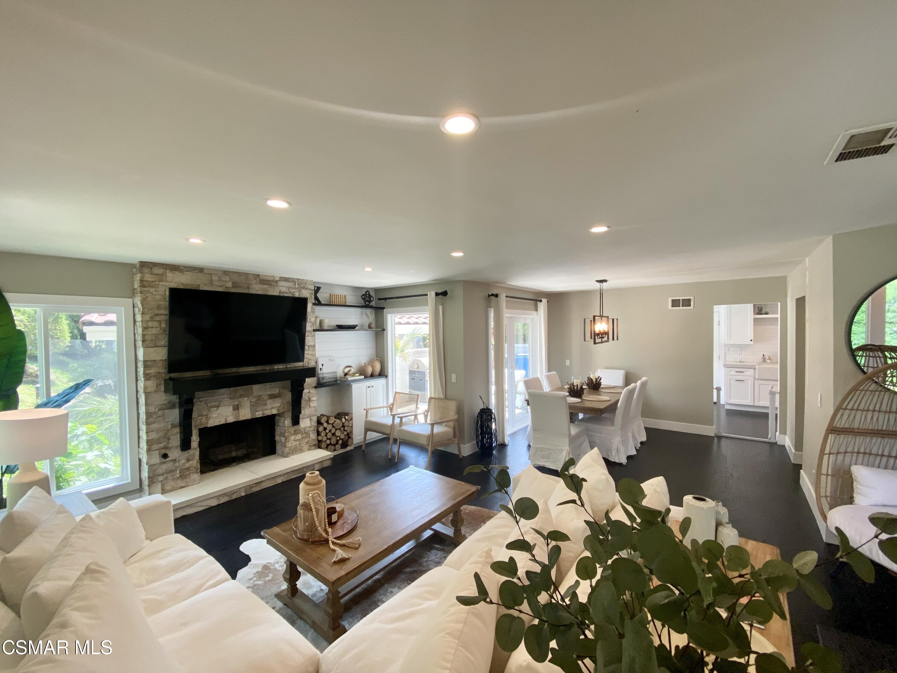 979 Thistlegate Road Oak Park, CA 91377 - Photo 5 of 19 a living room with furniture flat screen tv and a fireplace
