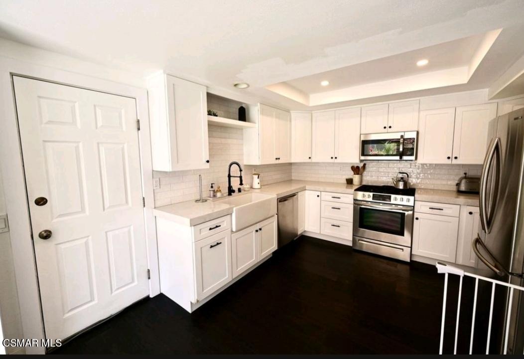 979 Thistlegate Road Oak Park, CA 91377 - Photo 9 of 19 a kitchen with granite countertop white cabinets and white appliances
