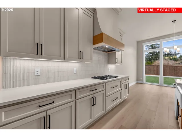 a kitchen with stainless steel appliances granite countertop a sink a stove and a wooden floors