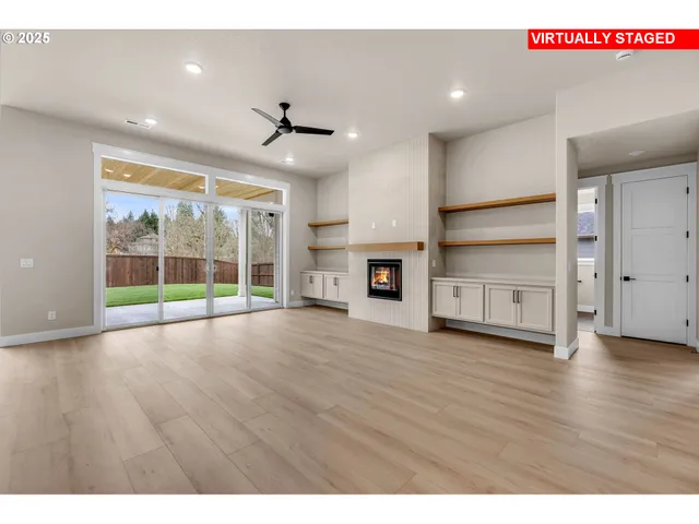 a view of empty room with wooden floor and fireplace