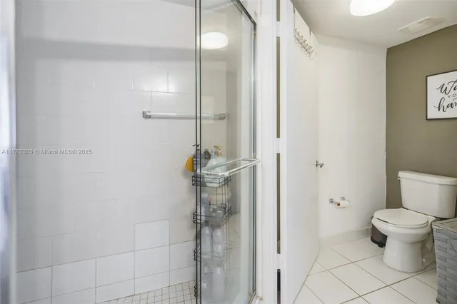 a spacious bedroom with a bed and a flat tv screen next to a window