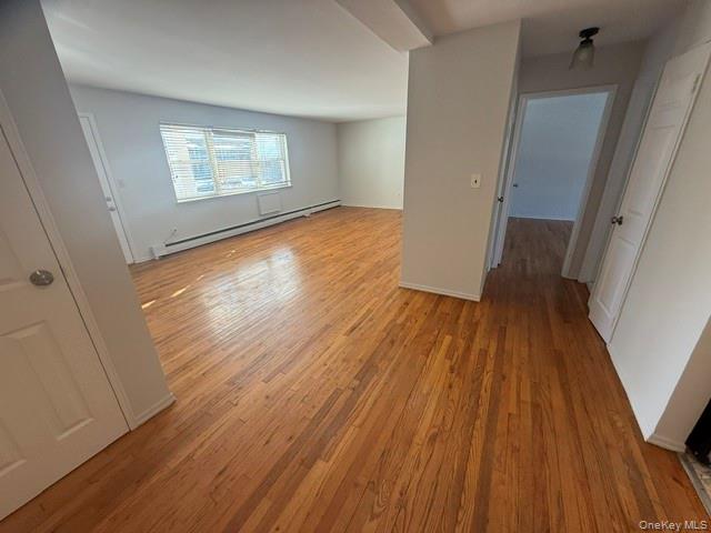 54 Ralph Avenue Babylon, NY 11702 - Photo 4 of 6 an empty room with wooden floor and windows