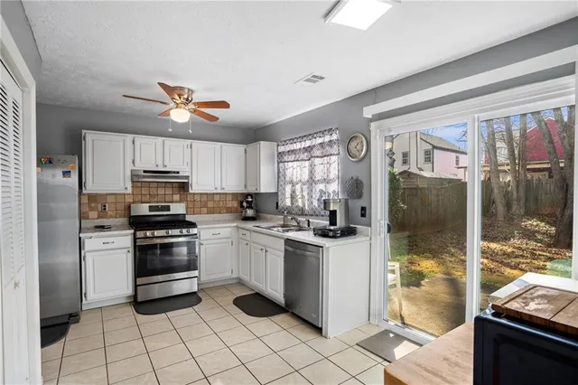 a kitchen with stainless steel appliances a stove a sink and a refrigerator