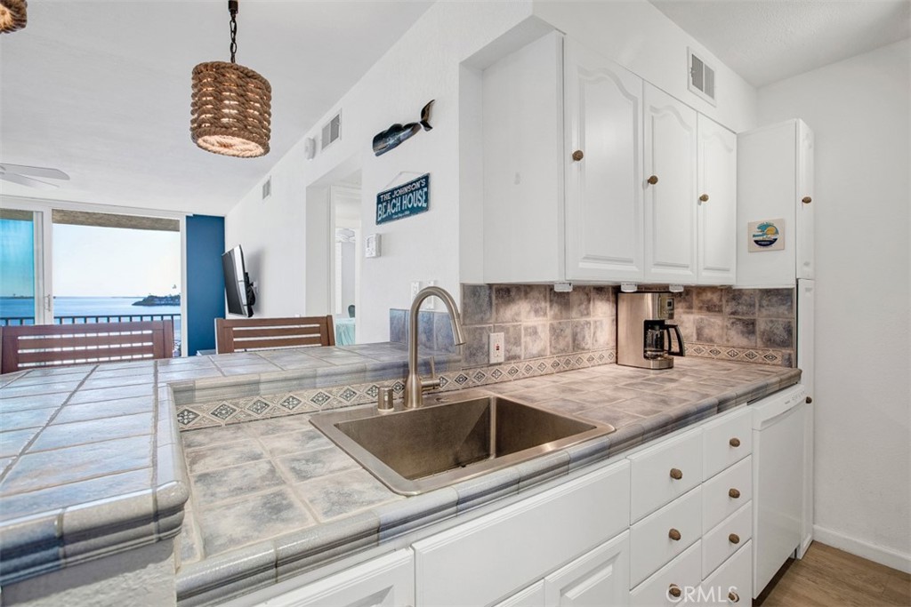 1140 East Ocean Boulevard, Unit 235 Long Beach, CA 90802 - Photo 8 of 45 a kitchen with granite countertop a sink a stove and cabinets
