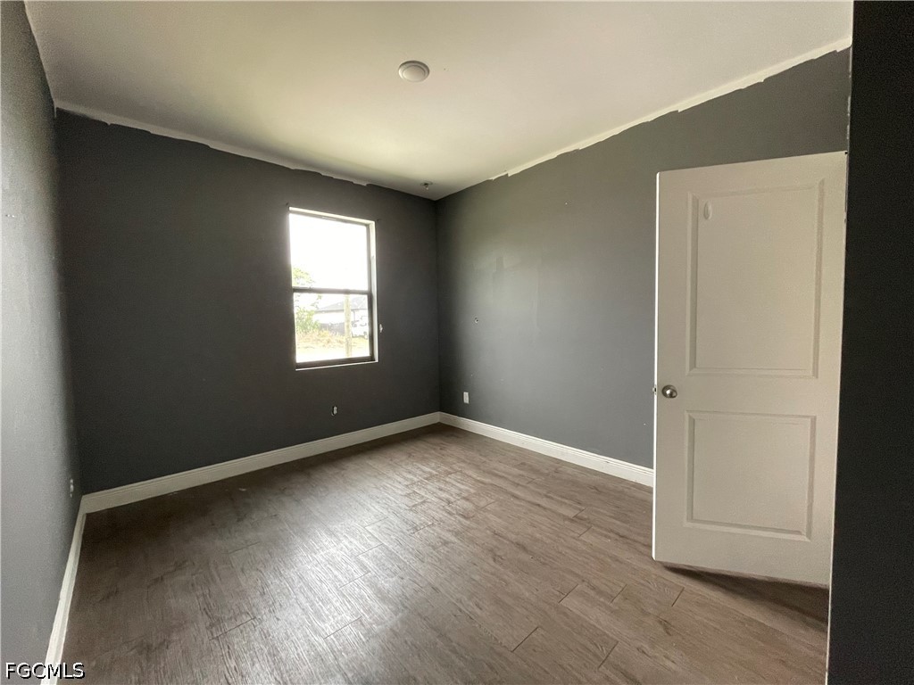 8046 Memory Circle LaBelle, FL 33935 - Photo 4 of 10 an empty room with wooden floor and windows