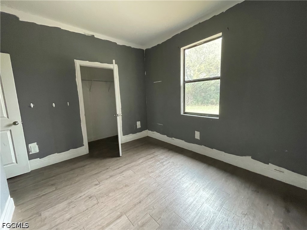 8046 Memory Circle LaBelle, FL 33935 - Photo 7 of 10 an empty room with wooden floor and windows