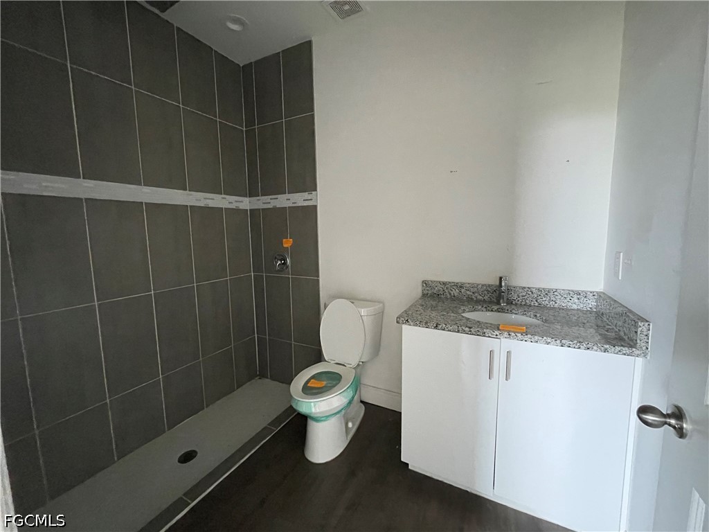 8046 Memory Circle LaBelle, FL 33935 - Photo 8 of 10 a bathroom with a granite countertop sink a toilet and a shower