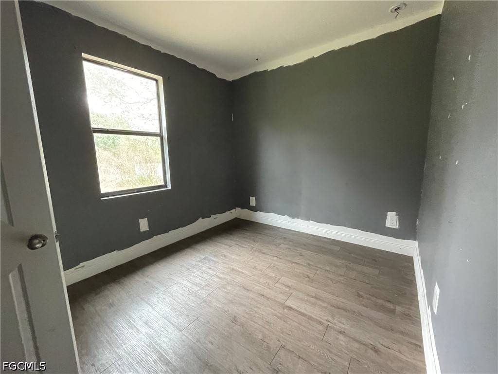 8046 Memory Circle LaBelle, FL 33935 - Photo 9 of 10 an empty room with wooden floor and windows