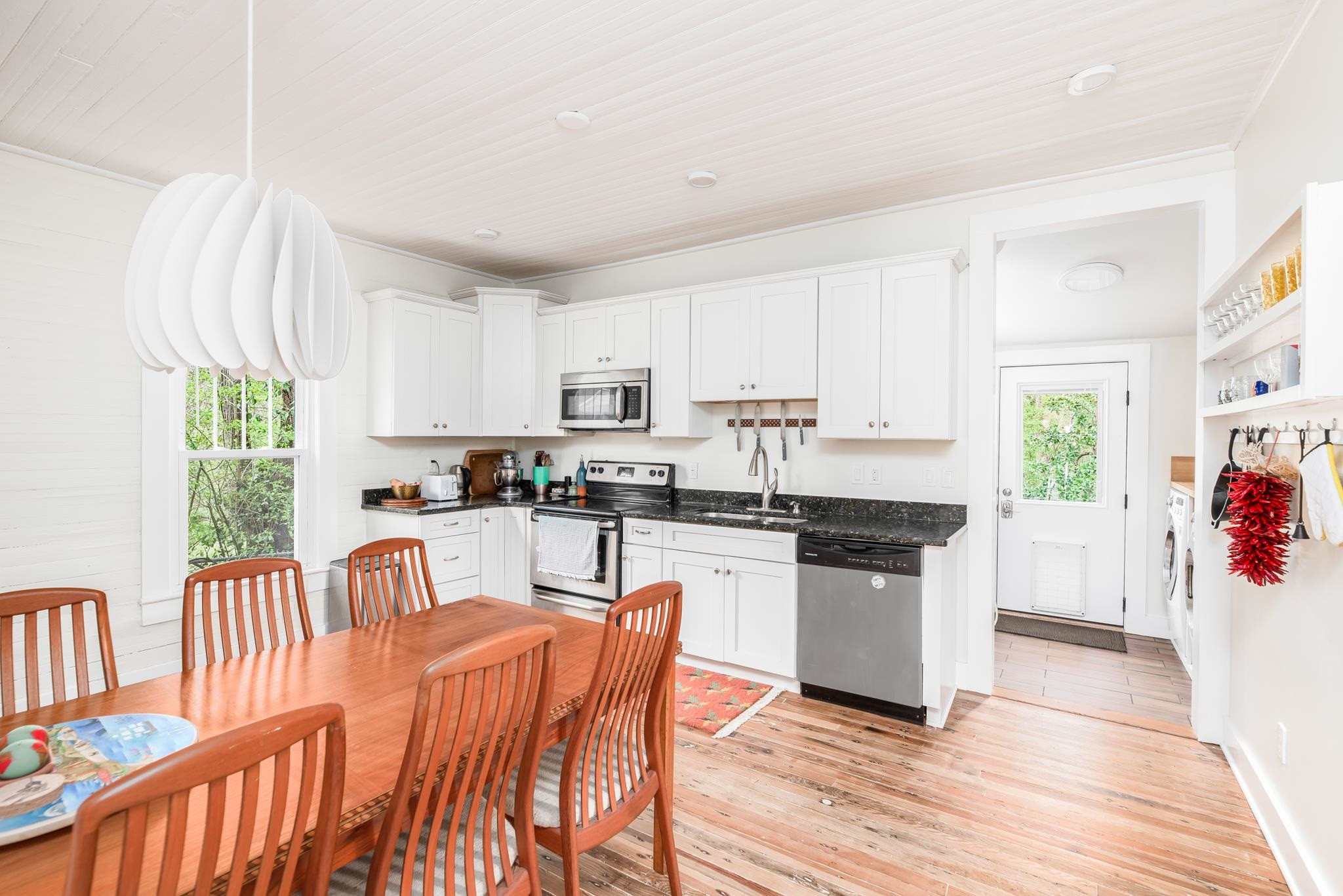 1112 Berkeley Street Durham, NC 27705 - Photo 4 of 23 a kitchen with stainless steel appliances granite countertop a stove a sink a refrigerator dining table and chairs