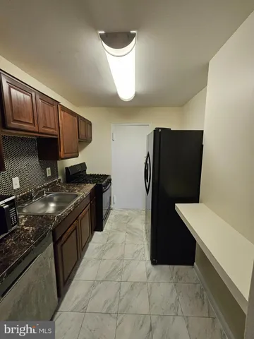 a kitchen with a refrigerator and a stove top oven