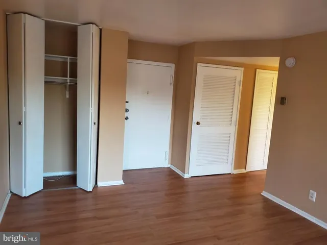 an empty room with wooden floor and closet
