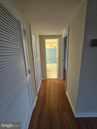 a view of a hallway with wooden floor