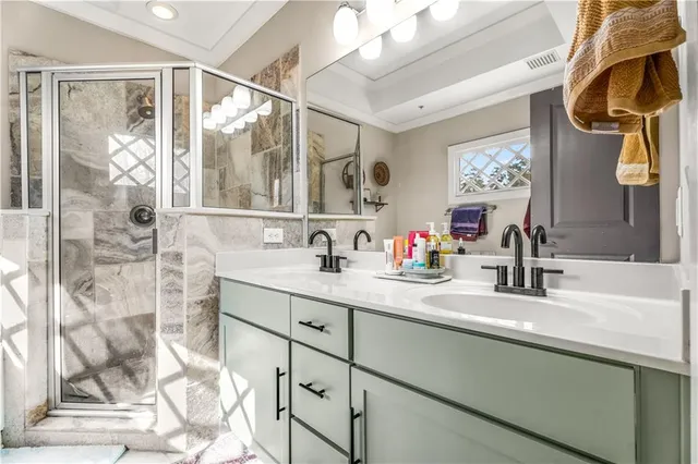 a bathroom with a double vanity sink mirror and shower