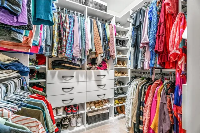 a view of walk in closet with clothes