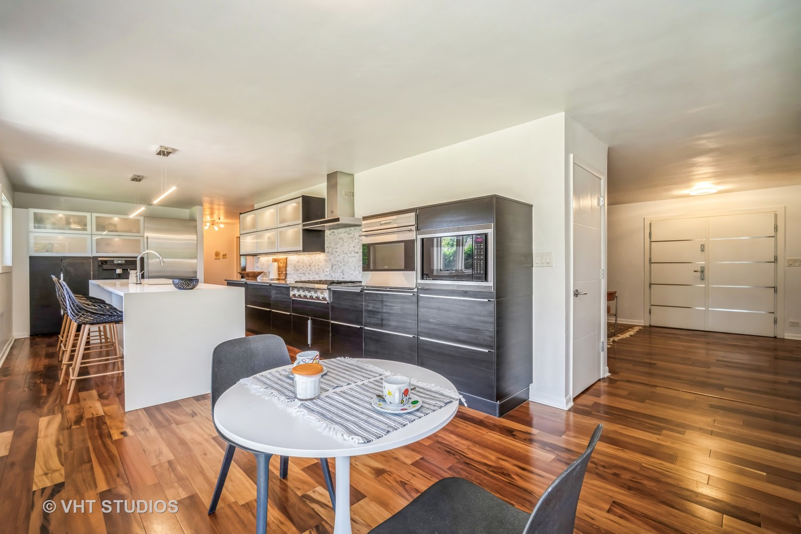 135 Birchwood Road Northbrook, IL 60062 - Photo 8 of 20 a kitchen with stainless steel appliances kitchen island granite countertop a refrigerator a stove a dining table and chairs with wooden floor