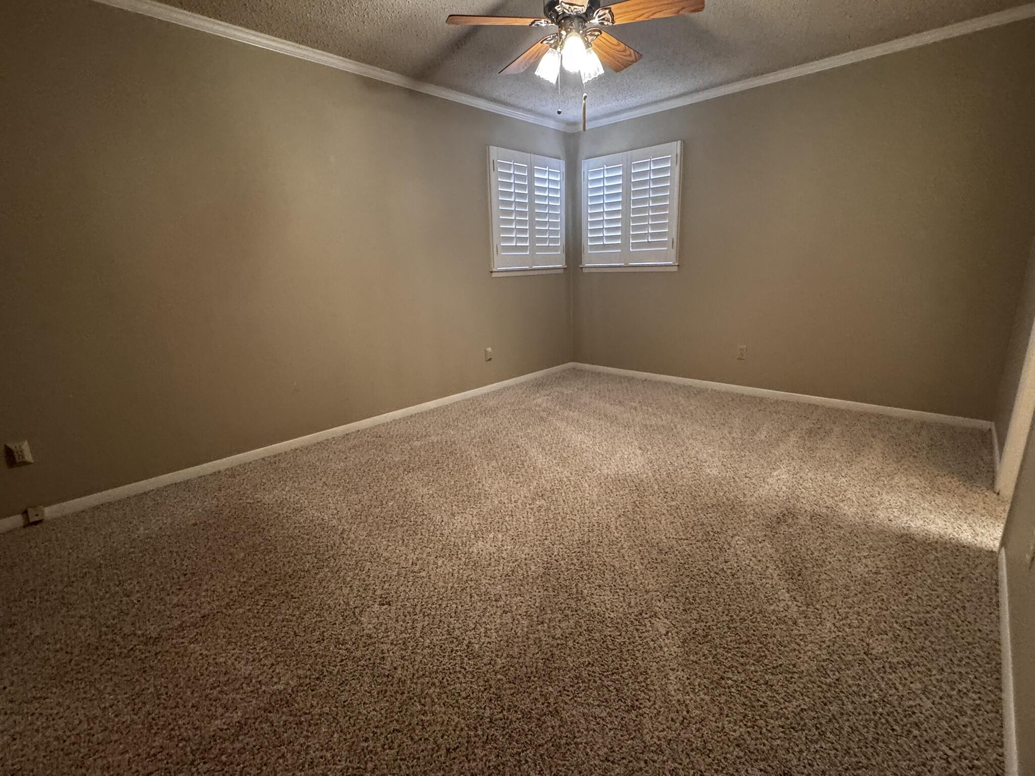 1304 Floydada Plainview, TX 79072 - Photo 23 of 49 en empty room with windows and chandelier fan