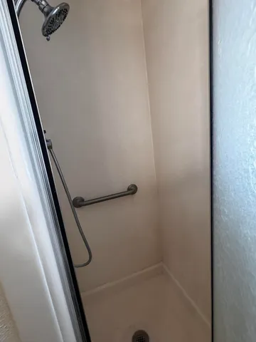 an empty room with windows and chandelier fan