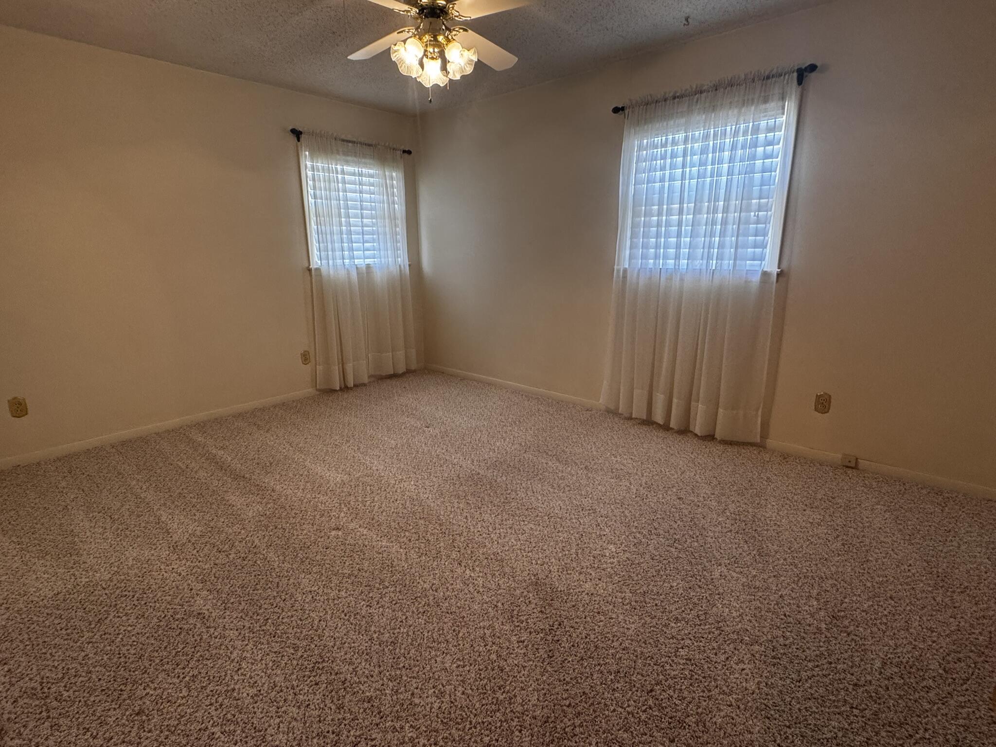 1304 Floydada Plainview, TX 79072 - Photo 28 of 49 an empty room with windows and chandelier fan
