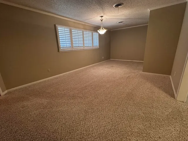an empty room with windows and chandelier fan