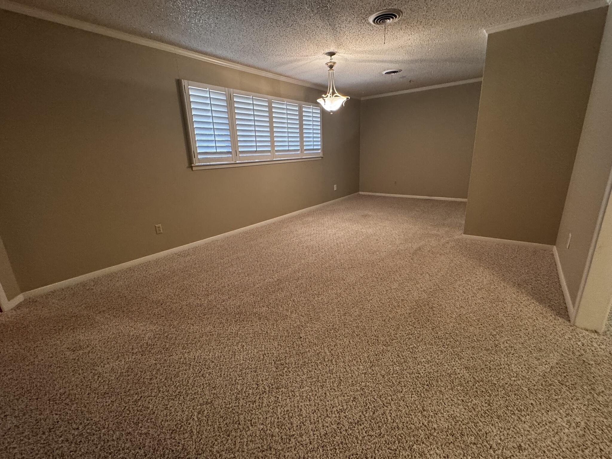 1304 Floydada Plainview, TX 79072 - Photo 9 of 49 an empty room with windows and chandelier fan