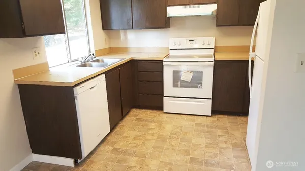 a kitchen with a sink a stove and cabinets