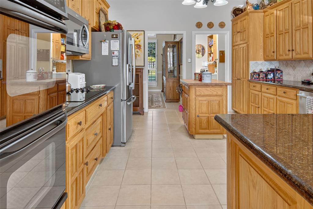 272 Edward Farris Road Weatherford, TX 76085 - Photo 15 of 40 Kitchen featuring wood cabinetry, stainless steel appliances, dark stone countertops, and a tile floor