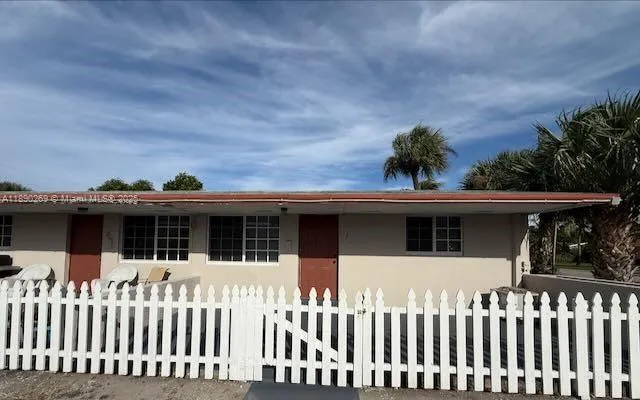 a front view of white house with a small yard