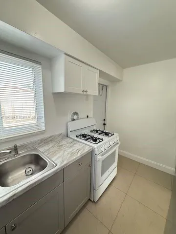 a kitchen with a stove sink and cabinets
