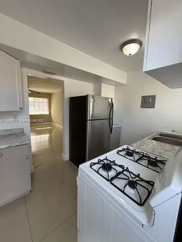 a kitchen with a refrigerator and a stove