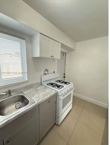 a kitchen with a stove sink and cabinets
