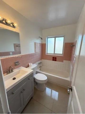 a bathroom with a double vanity sink toilet mirror and bathtub