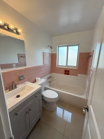 a bathroom with a sink a toilet a tub and mirror
