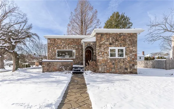 a front view of a house with a yard covered with snow in the background