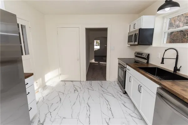 a kitchen with granite countertop a sink stove and refrigerator