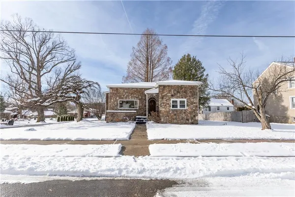a front view of a house with a yard covered with snow