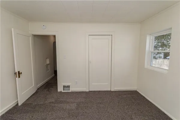 an empty room with windows and closet