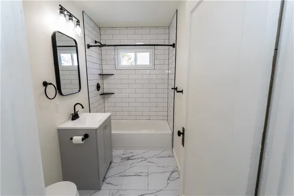 a bathroom with a sink a toilet and shower