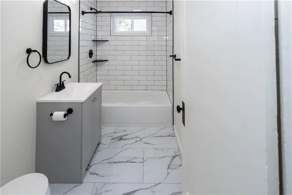 a bathroom with a sink a toilet and shower