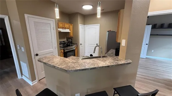a kitchen with stainless steel appliances granite countertop a sink stove and refrigerator