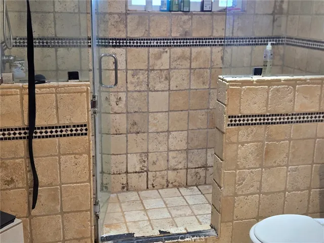 a bathroom with a toilet and a shower